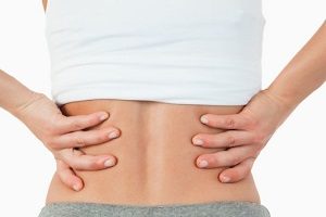 почему после дефекации болит спина