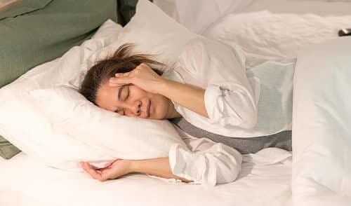 Внезапный приступ мигрени у женщины в постели